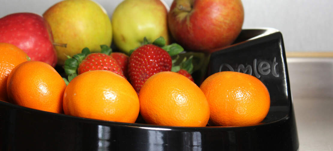 Un bol rolla noir avec des fruits dessus