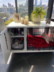 Une caisse pour chien blanche Fido avec une partie armoire et un lit pour chien gris