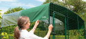 Femme attachant le couvercle du catio pour le walk in run extérieur
