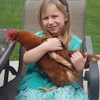 Fille tenant un poulet