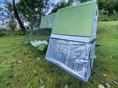 Un poulailler Eglu Go up avec des couvertures transparentes à l'arrière.