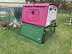 Un grand poulailler violet Cube avec un parcours attaché avec des couvertures sur le dessus