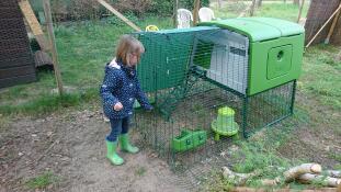 Fille avec Omlet vert Eglu Cube grand poulailler et parcours dans le jardin