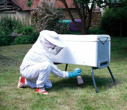 Une ruche blanche Beehaus avec du smooker liquide utilisé.