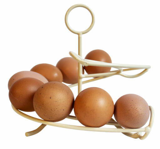 Un casseur d'œufs de couleur crème avec beaucoup d'œufs dessus