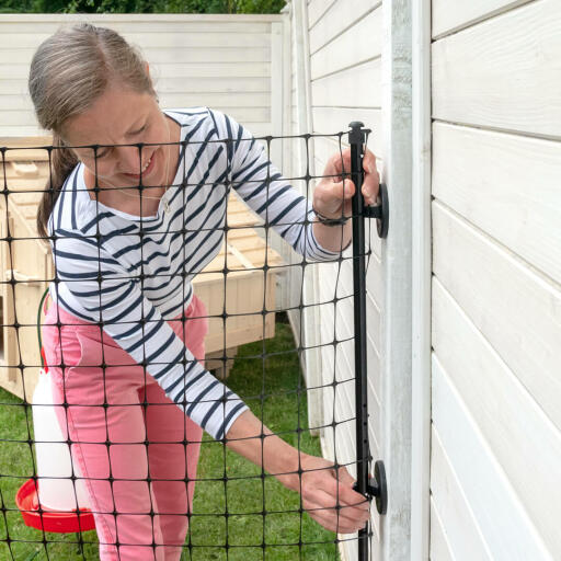 Fixer le grillage à poules Omlet au mur à l'aide des connecteurs muraux.