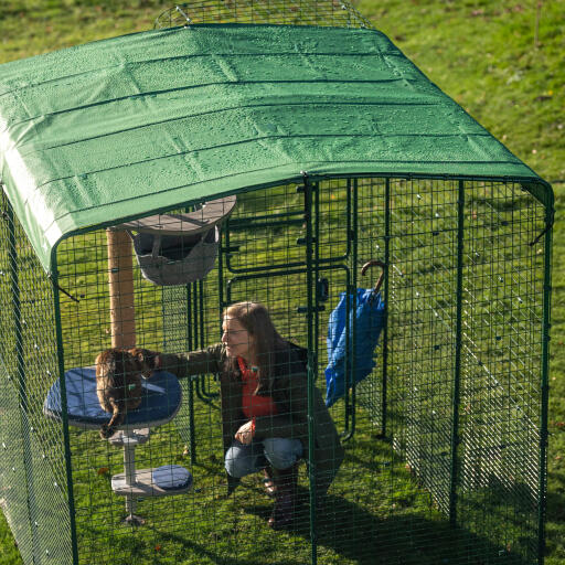 Le propriétaire et le chat sous une couverture résistante dans un parc de promenade.