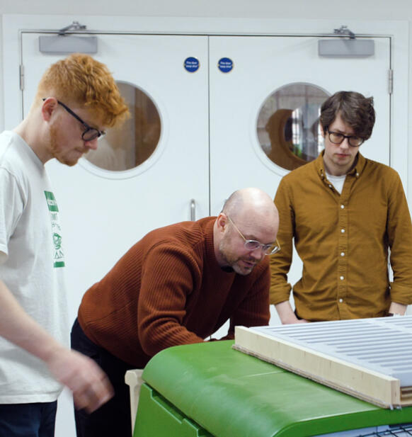 Quatre hommes examinant le poulailler Eglu Cube dans un atelier