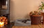 Un petit chien noir couché sur un lit à traversin en mousse à mémoire de forme gris dans un salon Un petit chien noir couché sur un lit à traversin en mousse à mémoire de forme gris dans un salon