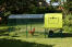 Vue de côté de Eglu Cube poulailler avec parcours, couvercle transparent et poulets Vue de côté de Eglu Cube poulailler avec parcours, couvercle transparent et poulets