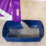 Verser la litière pour chats en argile Omlet dans le bac à litière