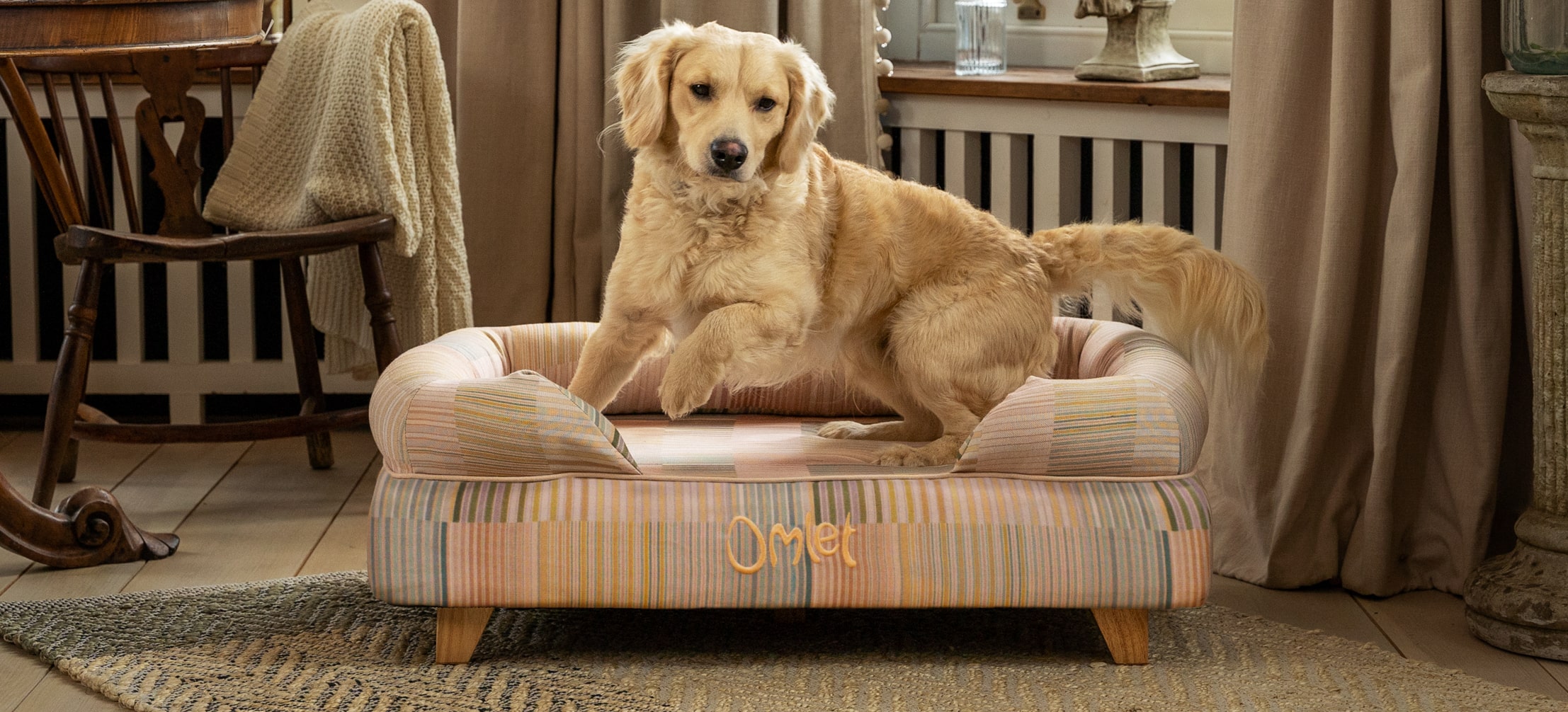 Un Golden Retriever qui utilise son panier pour chien Bolster d’Omlet en imprimé Pawsteps Natural