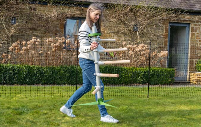 Femme qui déplace facilement le perchoir pour poules sur pied